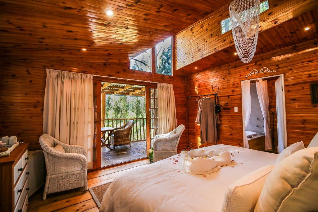 ein Schlafzimmer mit einem großen Bett und einem Balkon in der Unterkunft Vindoux Tree House Guest Farm & Spa in Tulbagh