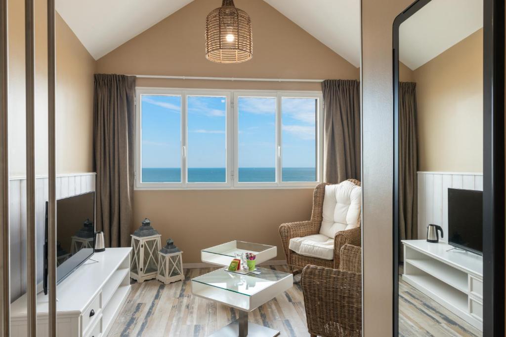 a living room with a view of the ocean at Hôtel de la Plage in Dieppe