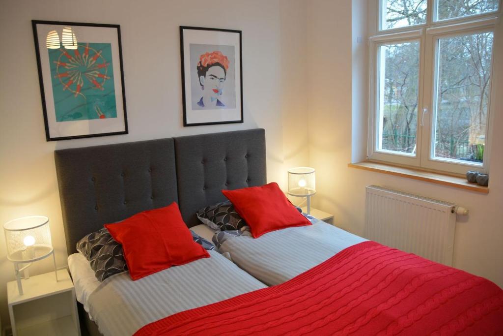 a bedroom with two beds with red pillows at Apartament 100m od morza in Sopot