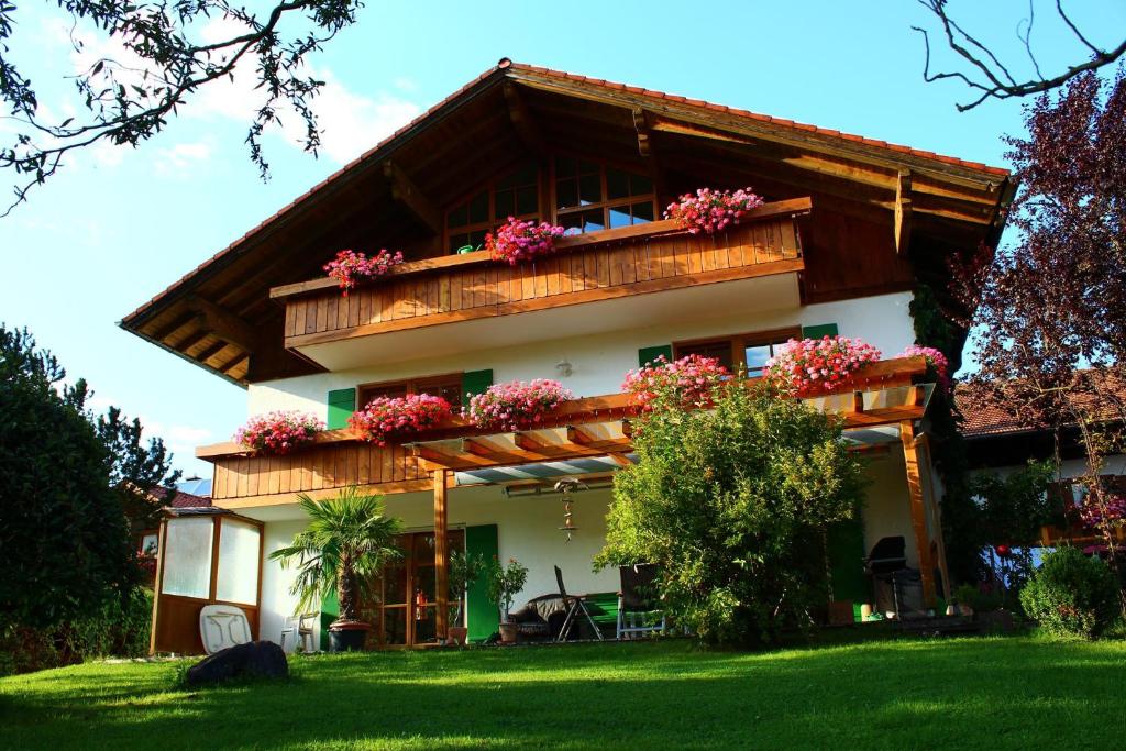 a house with a balcony with flowers on it at Ferienhaus Scholz in Rieden am Forggensee