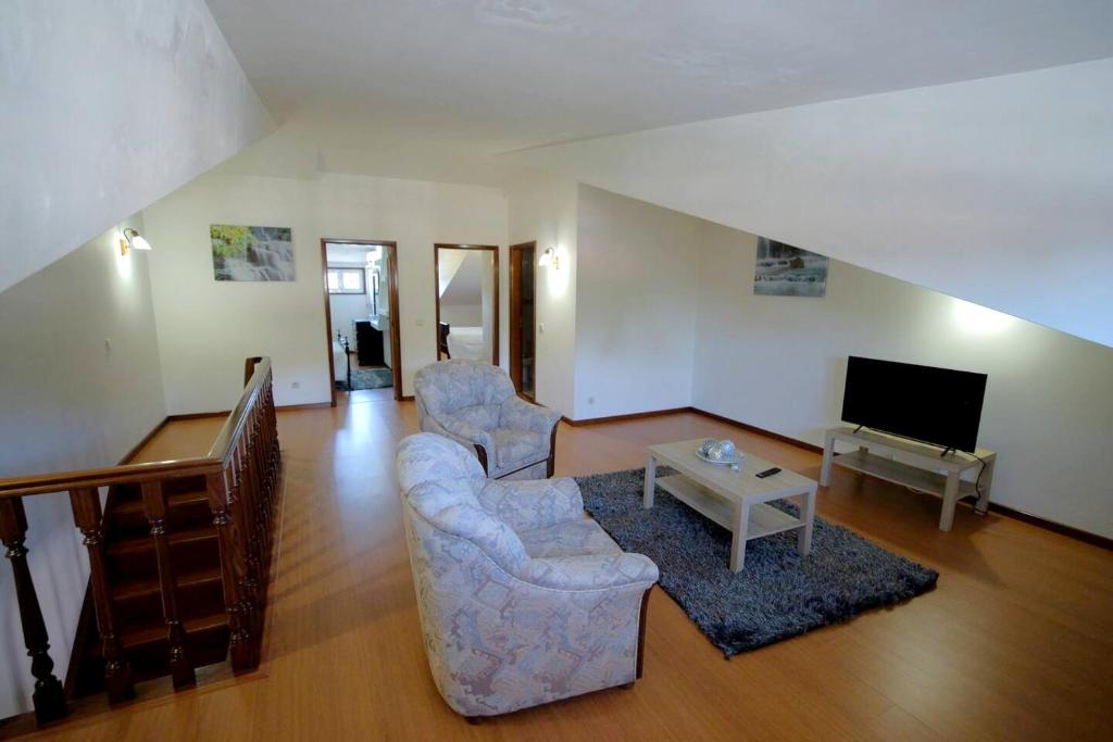 sala de estar con 2 sillas y TV en 4 bedrooms house with city view balcony and wifi at Santa Maria da Feira, en Aveiro