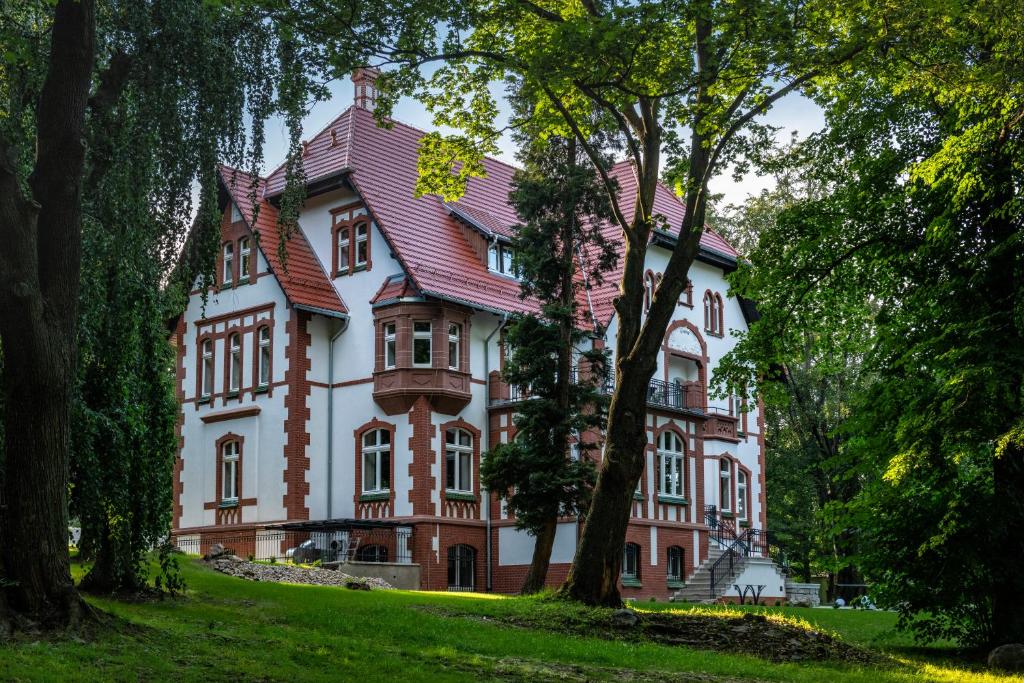 duży dom z drzewami przed nim w obiekcie Hotel Villam w mieście Bielawa