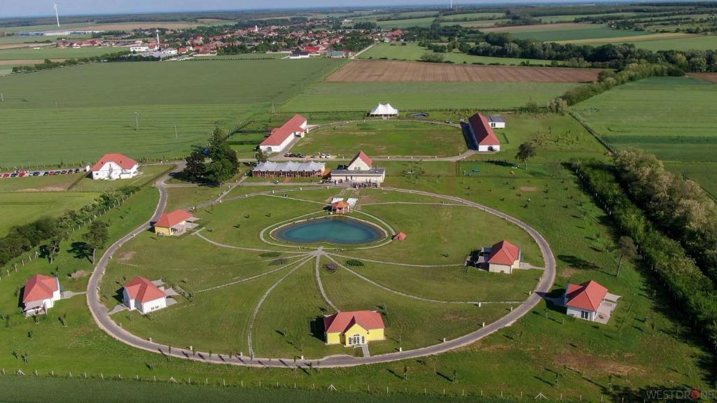 an aerial view of a farm with a pond at Chalets Franciska Major, Pro Village in Sopronkövesd
