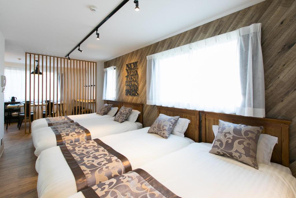 een groep van vier bedden in een kamer bij wisdom minosima inn in Fukuoka