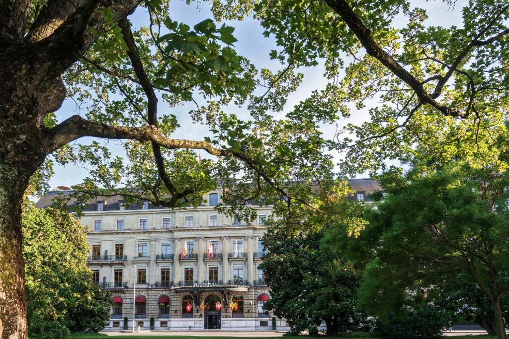 ein großes weißes Gebäude mit Bäumen davor in der Unterkunft Hôtel Métropole Genève in Genf