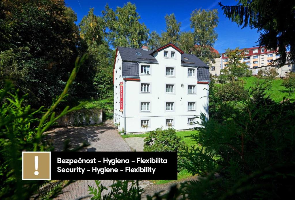 a white building with a black roof at Pytloun Penzion Zelený Háj in Liberec