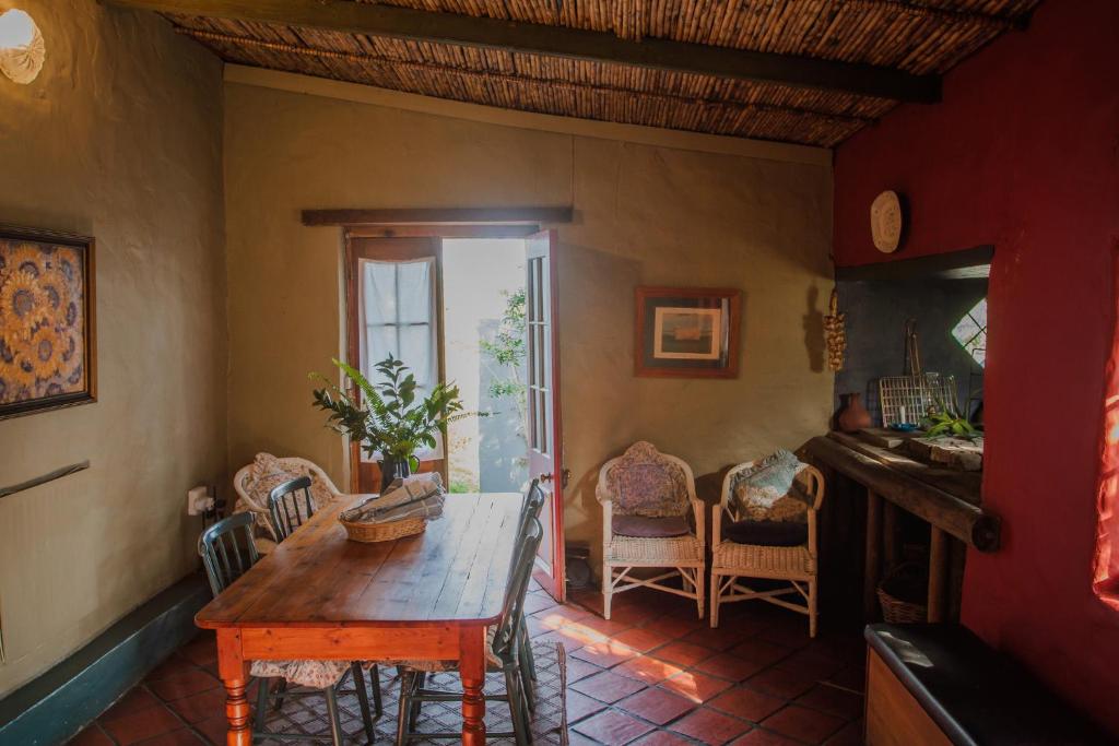 a dining room with a wooden table and chairs at Bo Kapie(1833) in Swellendam
