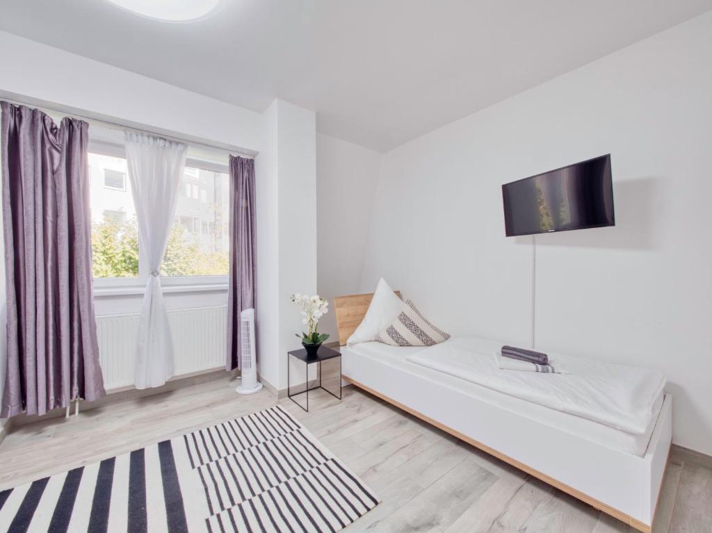 ein weißes Zimmer mit einem Bett und einem Fenster in der Unterkunft Pension Amanda in Berlin