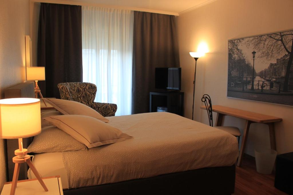 Una cama o camas en una habitación de Hotel Les Arcades