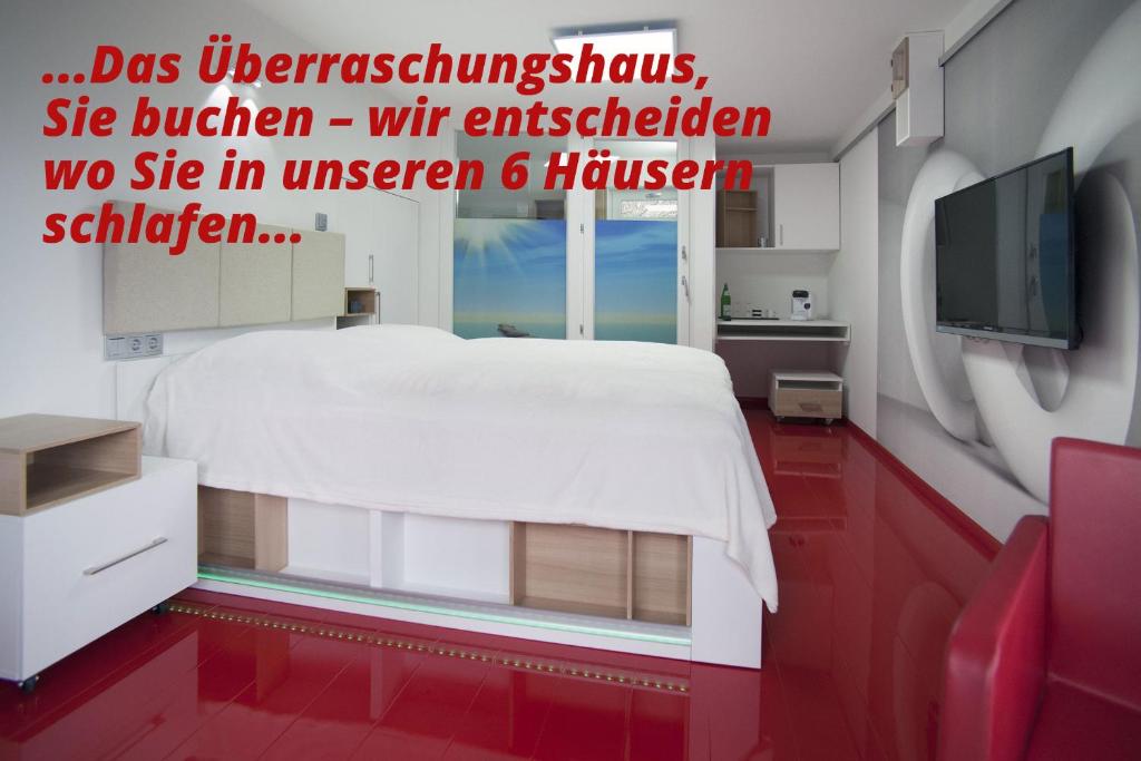 - une chambre avec un lit blanc et une télévision dans l'établissement Boutique-Hotel UPGRADE, à Wernigerode