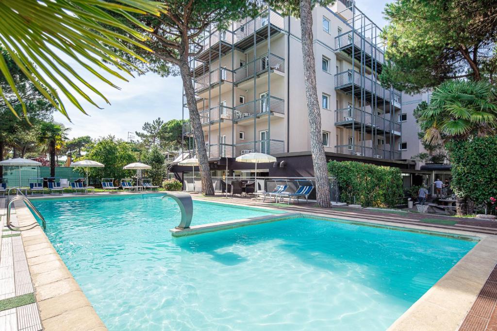 a swimming pool in front of a building at Hotel Martini in Lignano Sabbiadoro
