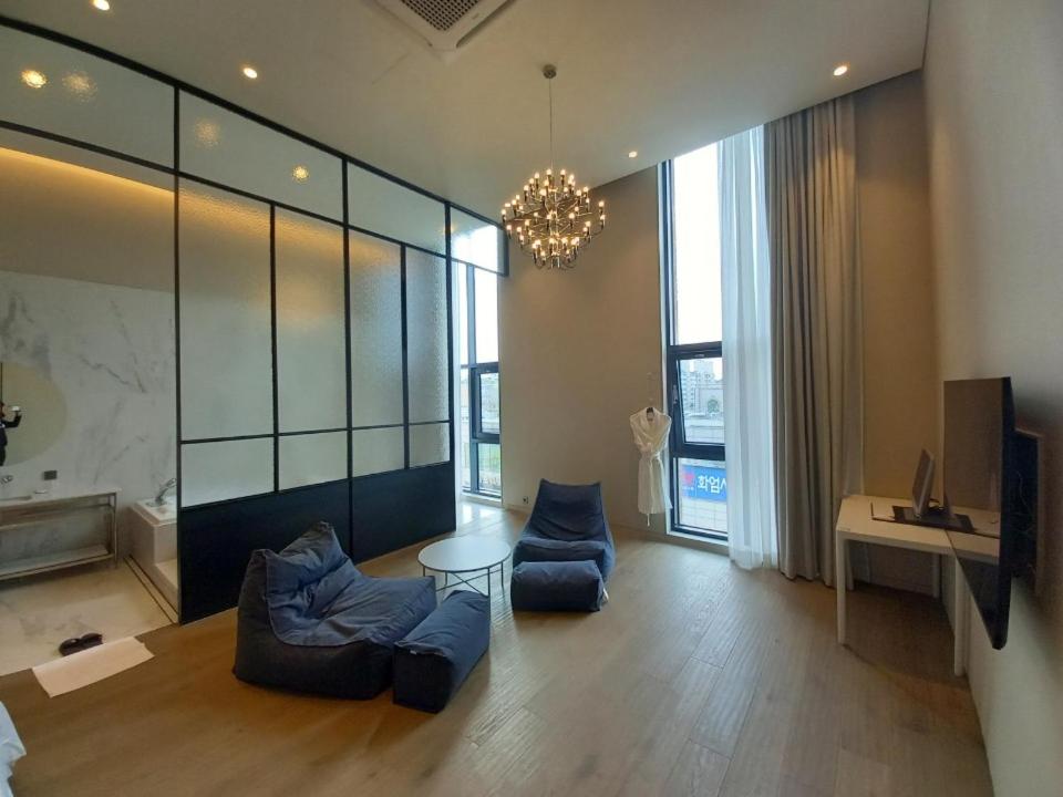 a living room with blue couches and a chandelier at Hotel Libre in Siheung