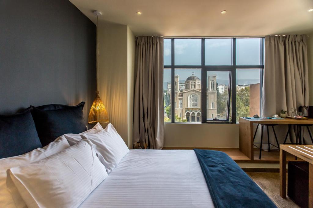 a hotel room with a bed and a large window at Ciel Living Athens in Athens