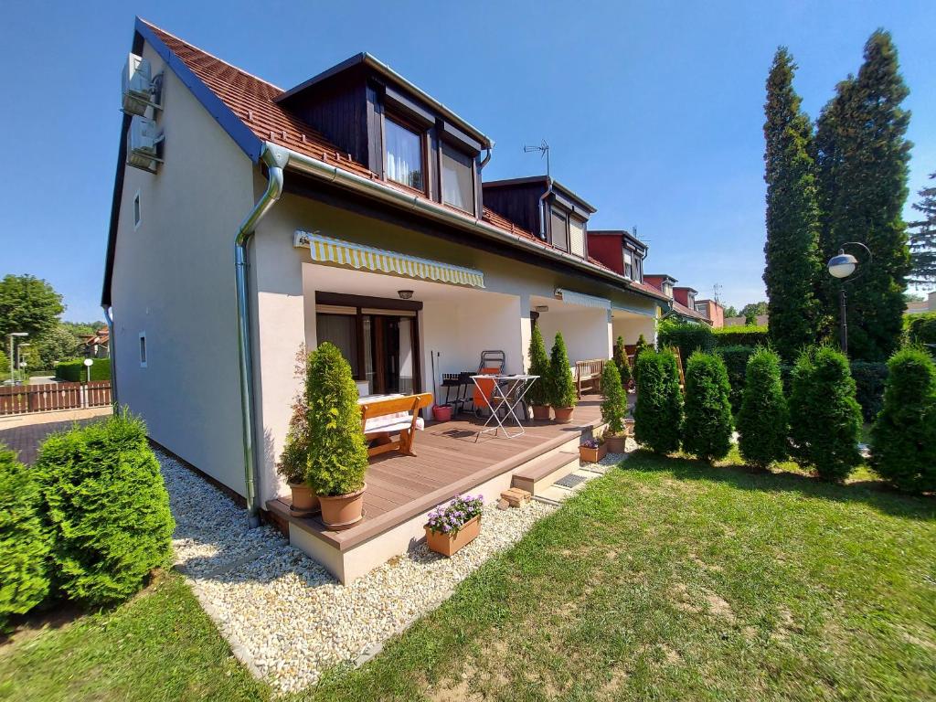 a house with a wooden deck in a yard at Apartman Őri in Bük