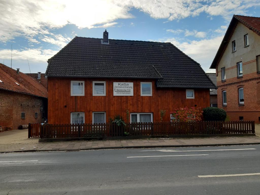 un edificio marrón con techo negro en una calle en Zimmervermietung KaSa, en Groß Lafferde