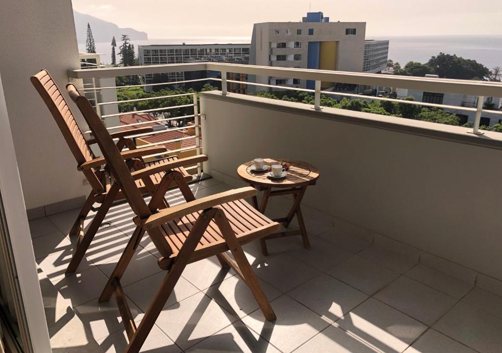 Duas cadeiras e uma mesa numa varanda em Dona I House - In Funchal with free parking no Funchal