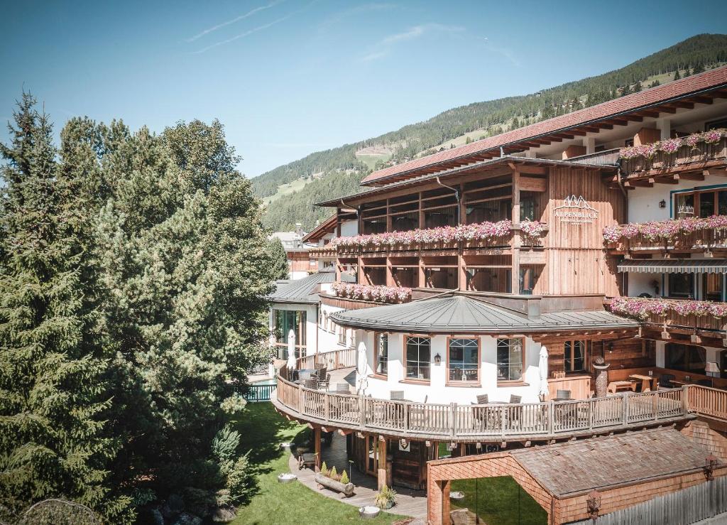 ein großes Gebäude mit einem Uhrturm darauf in der Unterkunft Hotel Alpenblick in Sexten