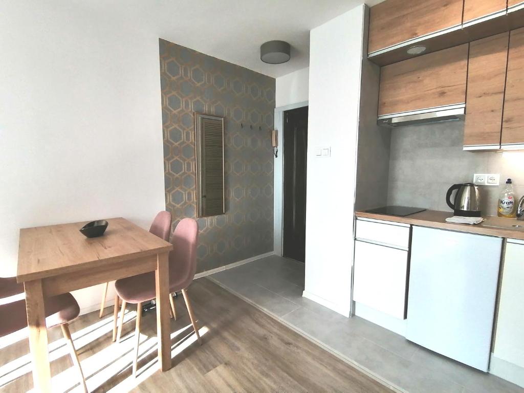 a kitchen and dining room with a table and chairs at City Apartments Studio in Zgorzelec