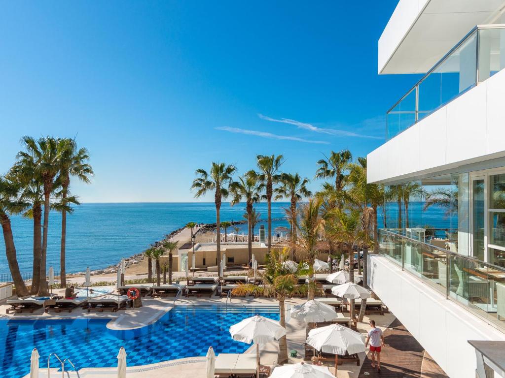 
a beach with a lot of palm trees at Amàre Beach Hotel Marbella - Adults Only in Marbella
