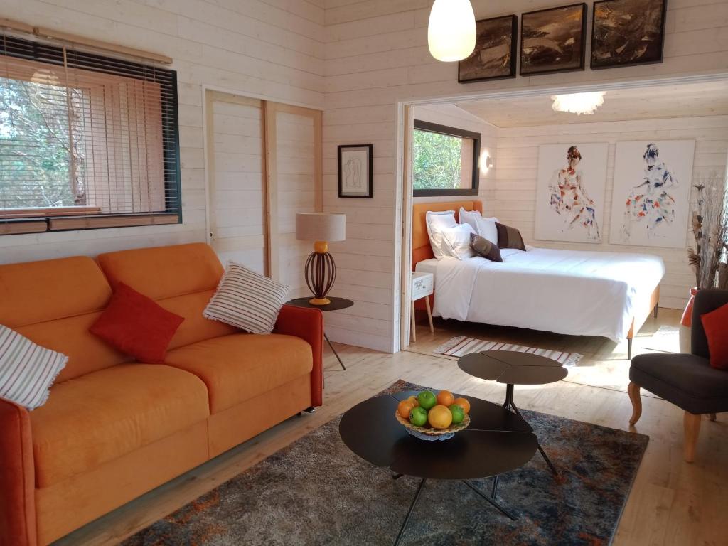 a living room with a couch and a bed at Les Lodges du golf de la Marterie in Saint-Félix-de-Reillac-et-Mortemart