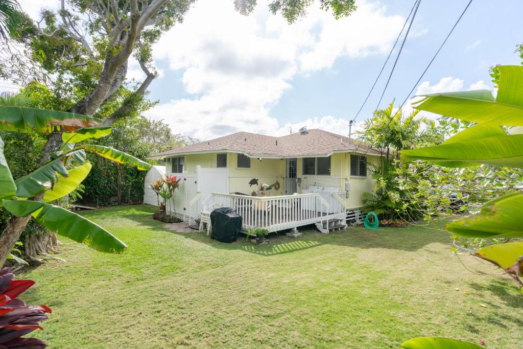 a yellow house with a large yard at Last Minute Deal! Stunning 2-Bedroom Beachfront House with AC in Kailua