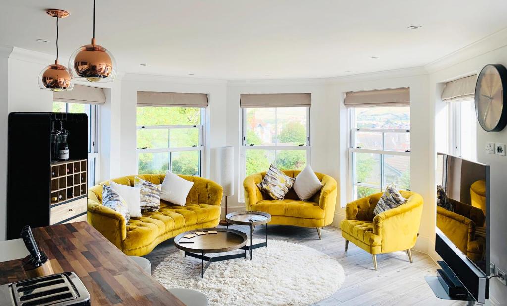 a living room with two yellow couches and a table at The Lookout in Swanage