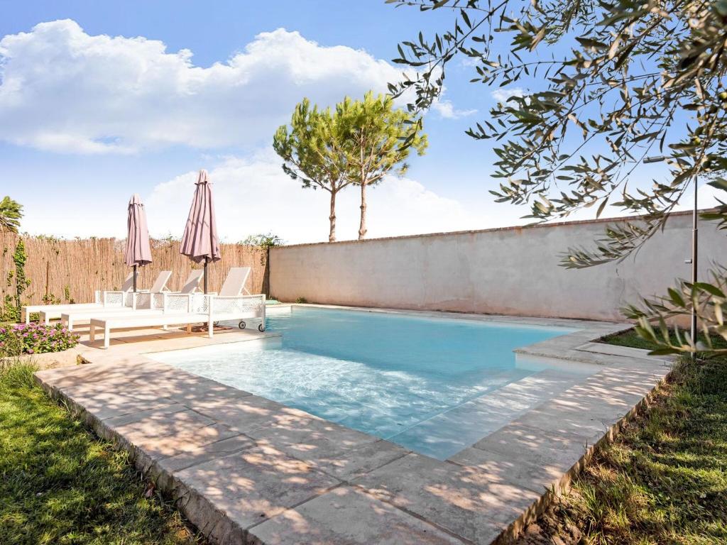 uma piscina no quintal de uma casa com dois guarda-sóis em Belvilla by OYO LA TORRE DE SEBASTIA em Fraga