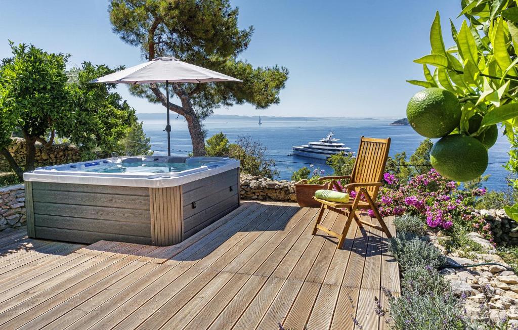 a hot tub on a wooden deck with an umbrella at Villa Karina - Unique location with jacuzzi in Split