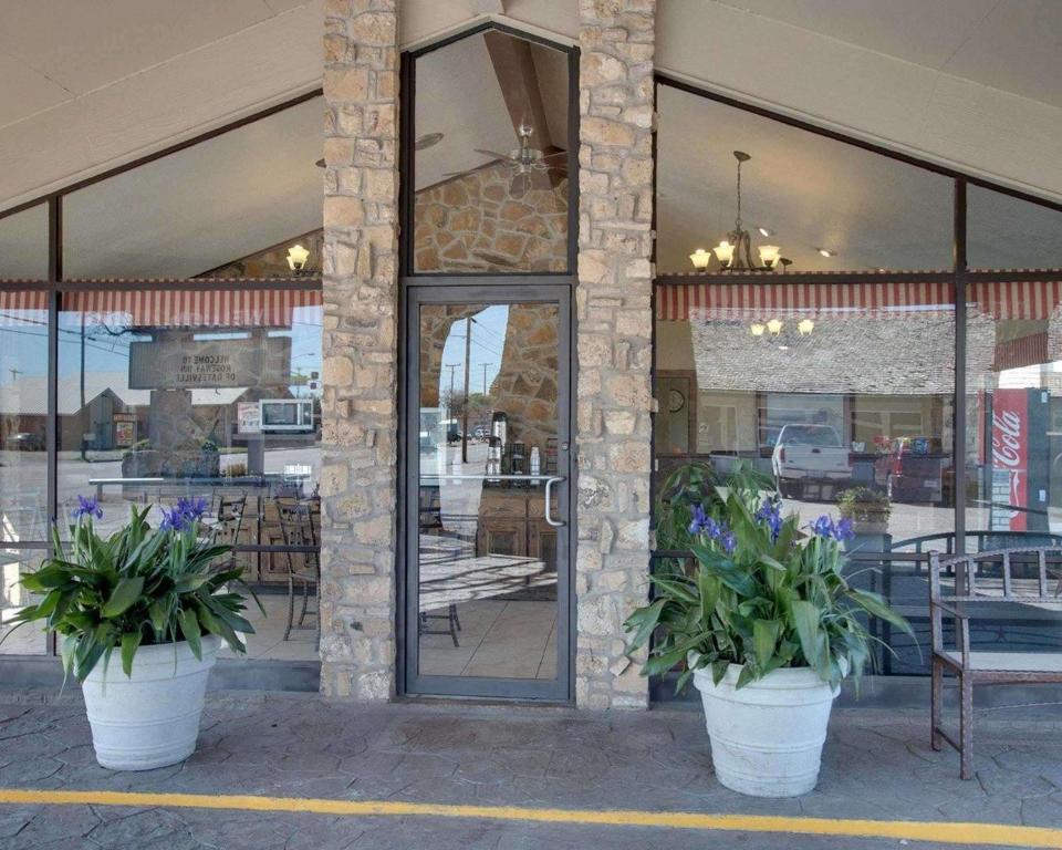 a restaurant with two potted plants in front of a building at Days Inn by Wyndham Gatesville in Gatesville