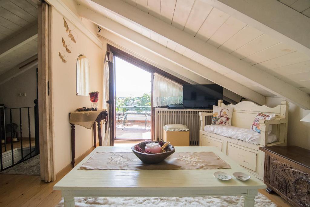 een woonkamer met een tafel en een groot raam bij cozy attic in Arachova