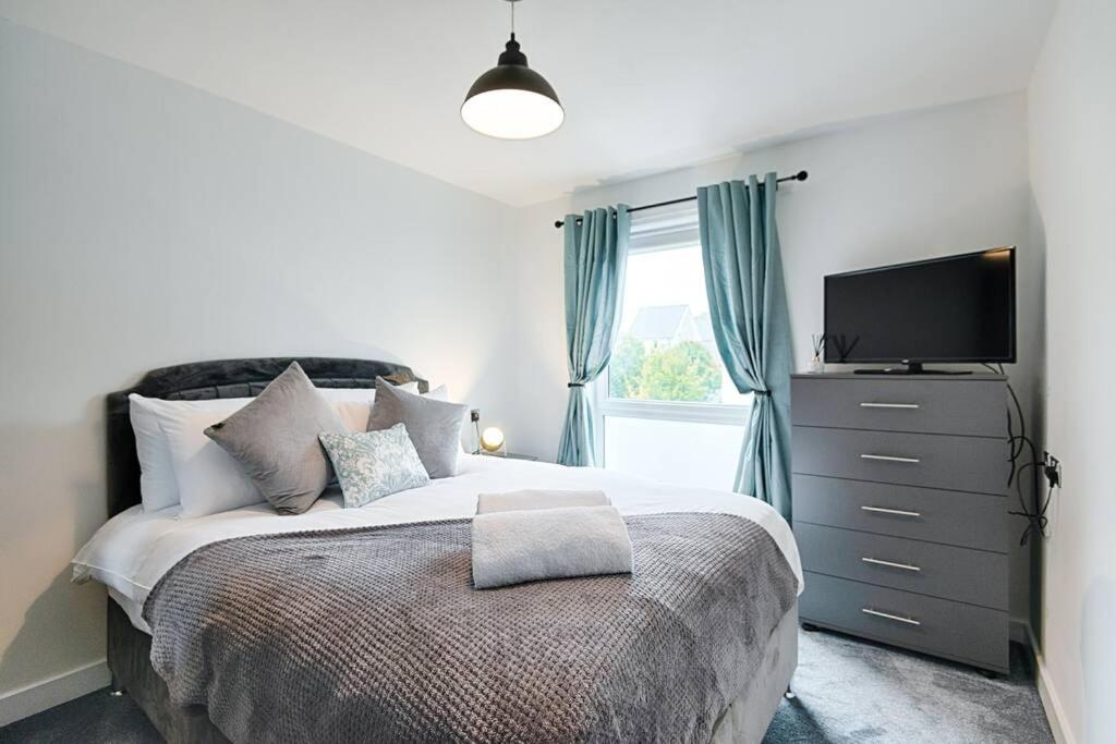 a bedroom with a large bed with a television on it at Stay at Neptune with Parking Space - TV in every Bedroom! in Swansea