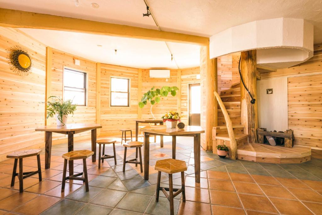 Habitación con paredes, mesas y taburetes de madera. en Ise Guest House Kazami en Ise