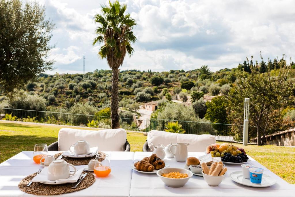 une table blanche avec de la nourriture au-dessus d'un champ dans l'établissement Domus Hyblaea Resort, à Palazzolo Acreide