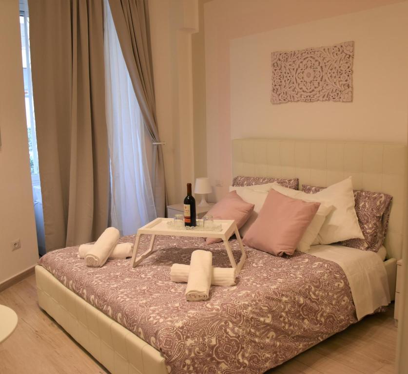 Una cama con una mesa con una botella de vino. en Lovely Nights Rome - Luxury rooms, en Roma