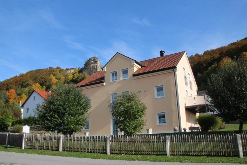 una casa con una valla delante de ella en Pension & Ferienwohnung Breitmoser Angelika, en Riedenburg