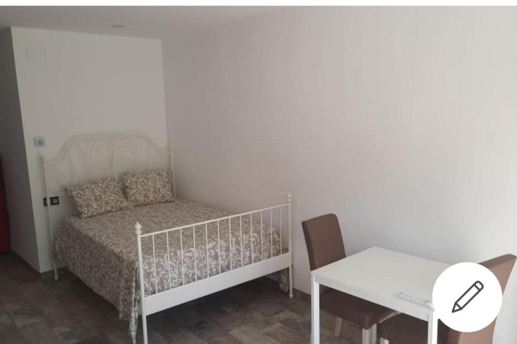 a small bedroom with a bed and a table and a desk at Loft con impresionantes vistas in Granada