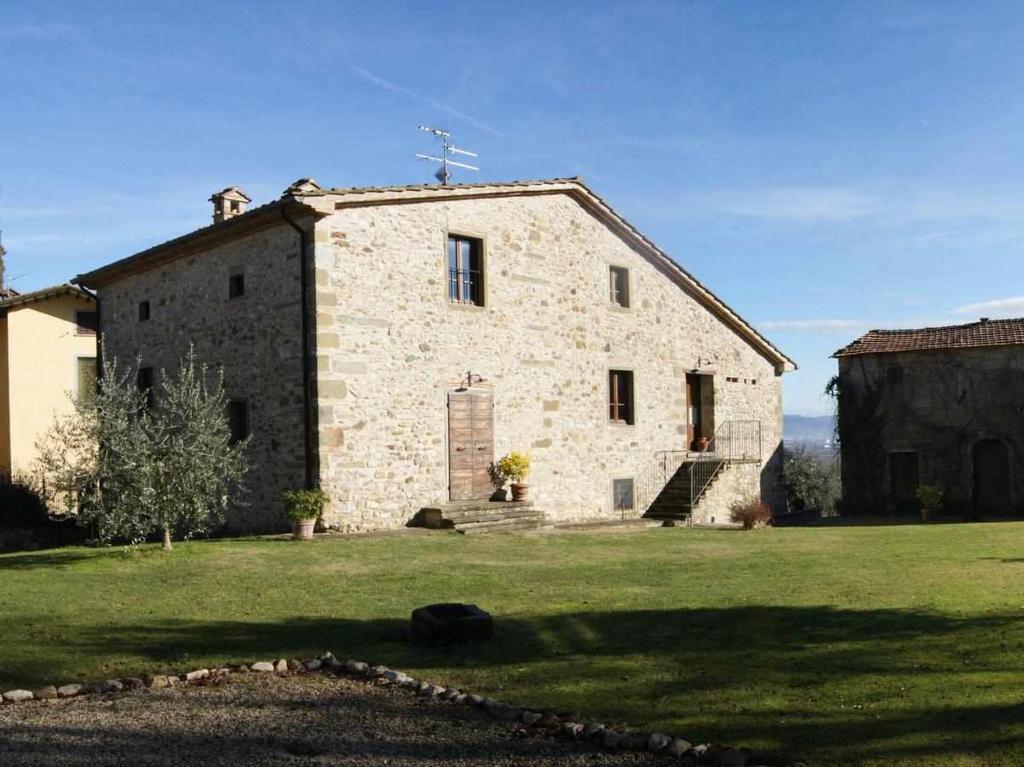 un ancien bâtiment en pierre avec une croix au-dessus dans l'établissement Appartamenti con cucina nelle colline toscane, à Anghiari