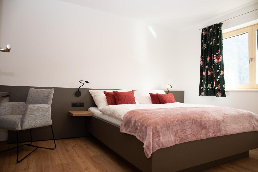 リート・イム・ツィラータールにあるDas Moosのベッドルーム1室(赤い枕のベッド1台、窓付)