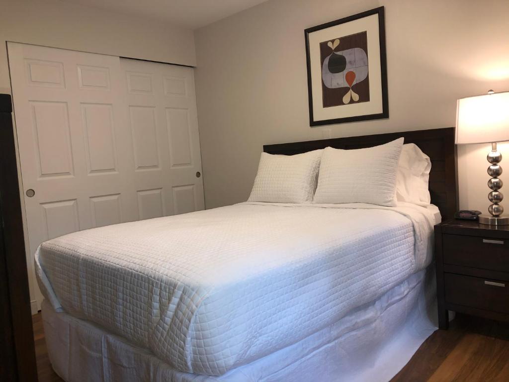 a bedroom with a large bed with white sheets at Boston Exclusive Corporate 30 Day Rental in Boston