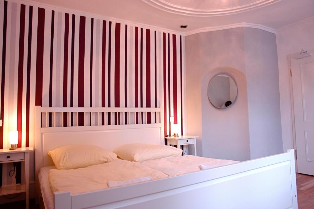 a bedroom with a white bed and striped walls at Lotte - The Backpackers in Heidelberg