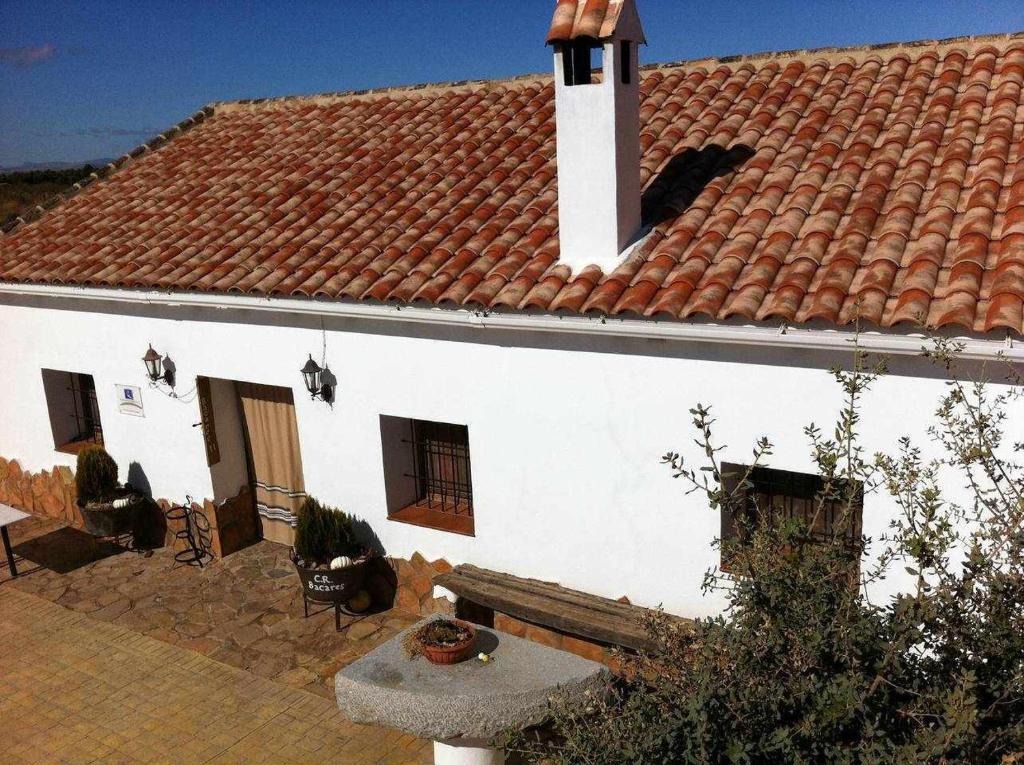 Biały dom z czerwonym dachem i patio w obiekcie Cortijo Rural Bacares w mieście Freila