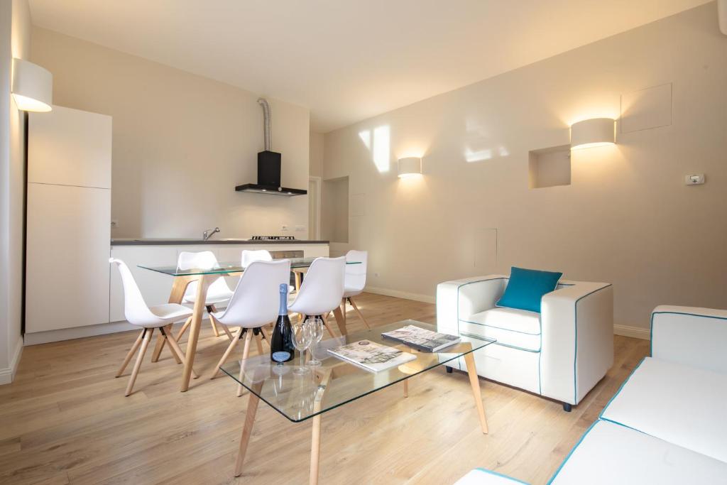 a living room with a table and white chairs at Ponte Vecchio White in Florence