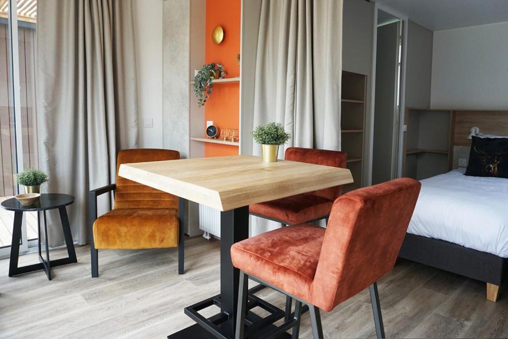 um quarto com uma mesa e cadeiras e uma cama em 2-persoons hotelkamer em Voorthuizen