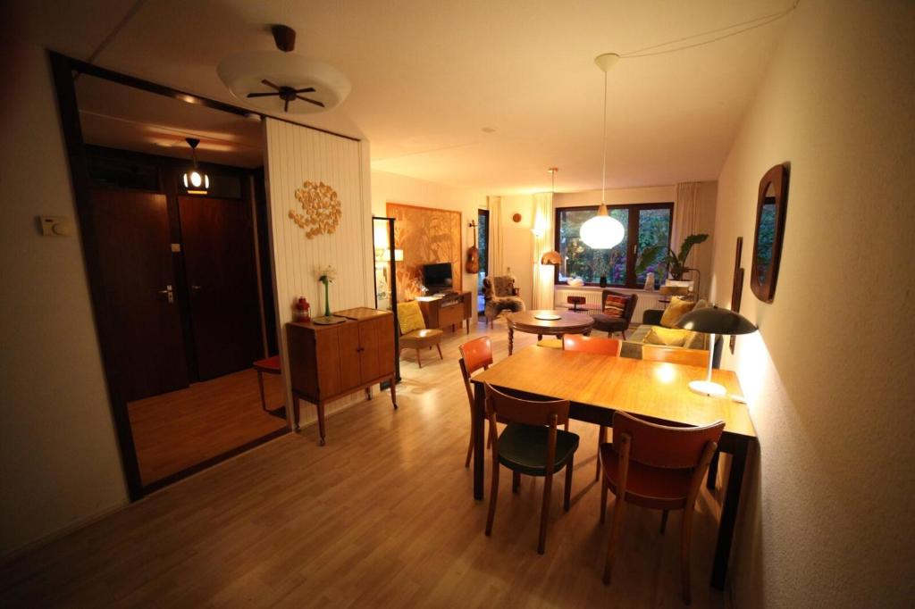 een eetkamer en een woonkamer met een tafel en stoelen bij Appartement - Kievitenlaan 1 Veere 'Nescio' in Veere