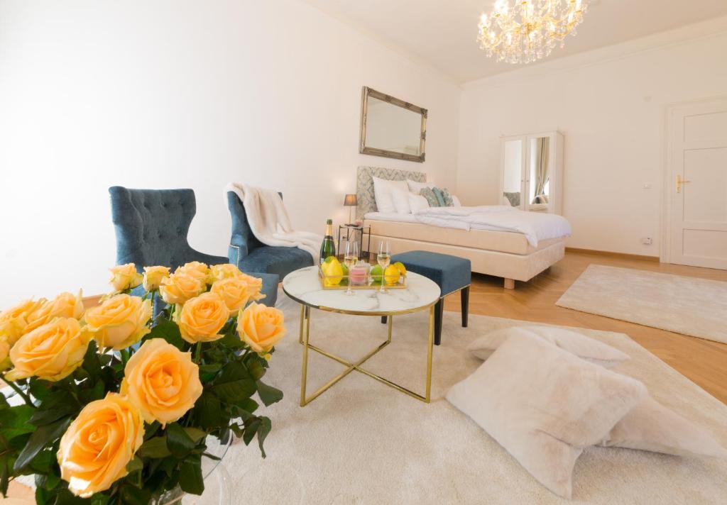 ein Wohnzimmer mit einem Tisch und gelben Rosen in der Unterkunft Palais Gutenberg l´atelier in Klagenfurt am Wörthersee