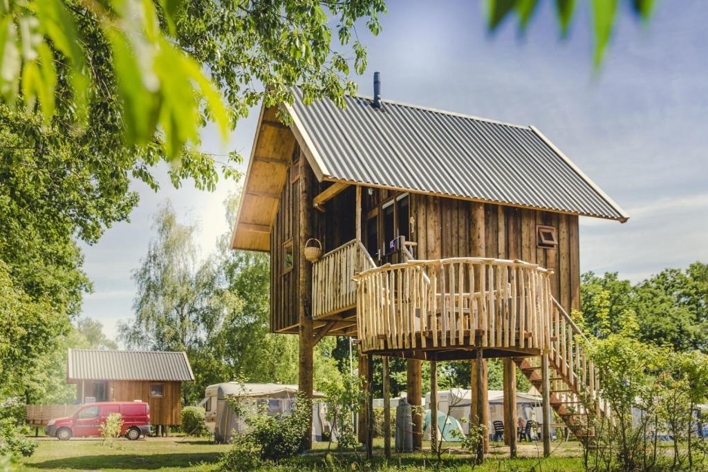 ein Baumhaus mit einer Terrasse und einer Treppe in der Unterkunft Tree house in Zuna