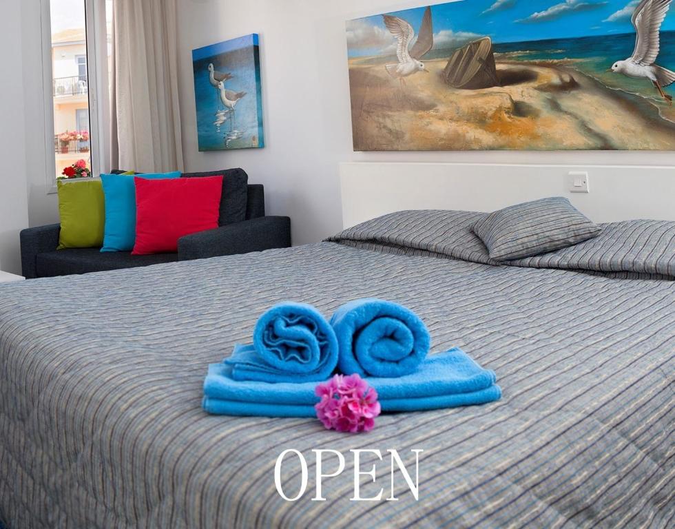 a bed with blue towels on top of it at Hotel Opera in Larnaca