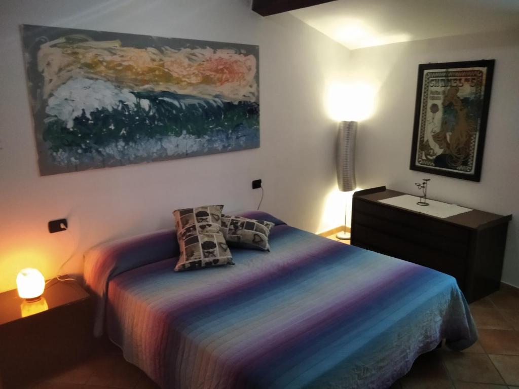 um quarto com uma cama e um quadro na parede em Il ponticello em Caprarola