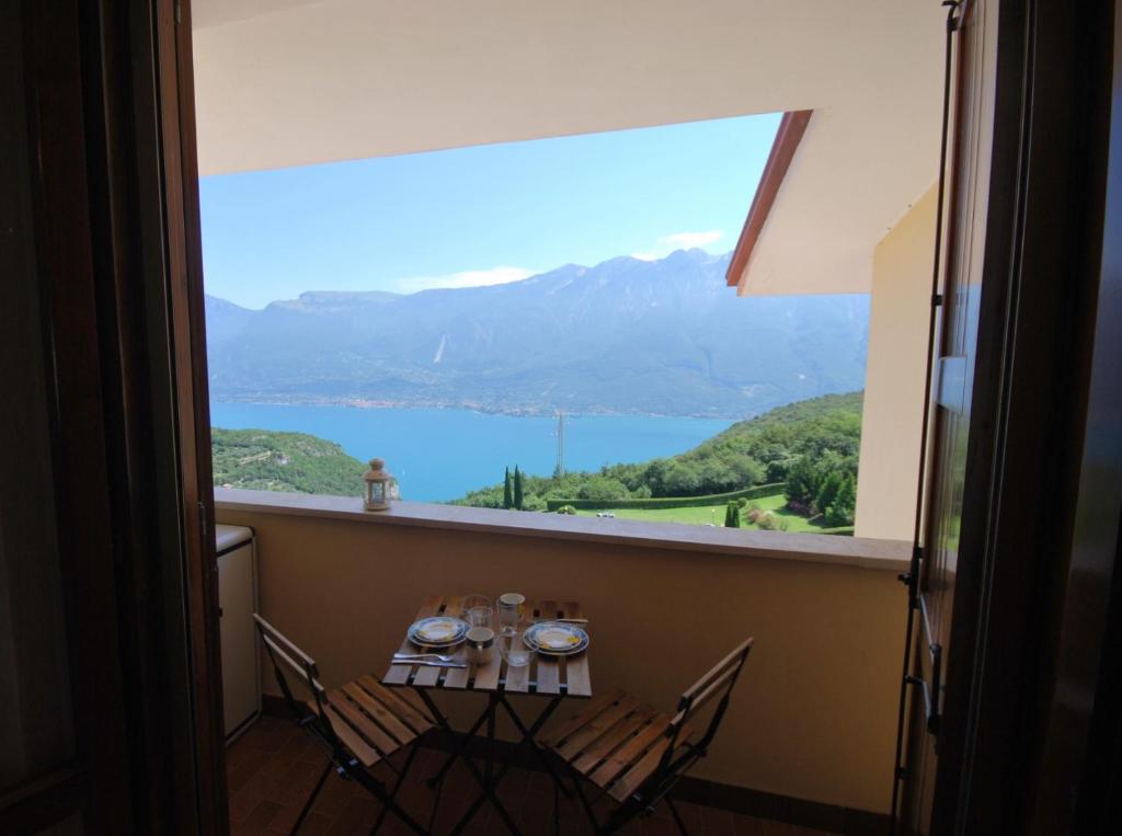 een tafel met stoelen en uitzicht op een berg bij Appartamento Nadia - Theater Home in Tignale