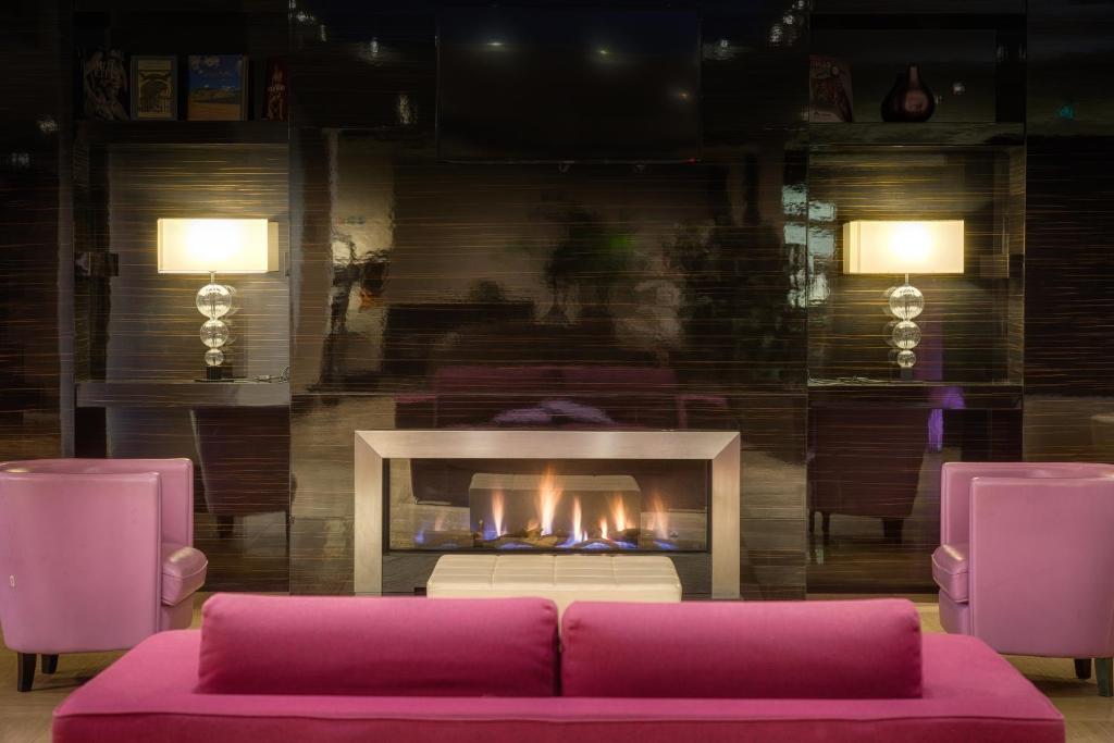 a living room with a couch and a fireplace at Quality Hotel Green Palace in Monterotondo